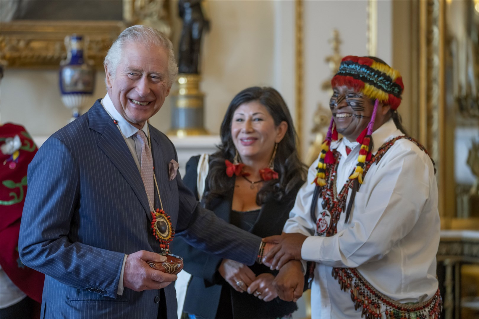 Domingo Peas, leader of the Achuar Nation of the Ecuadorian Amazon, presents his gifts to the King at Buckingham Palace (Kin Cheung/PA)