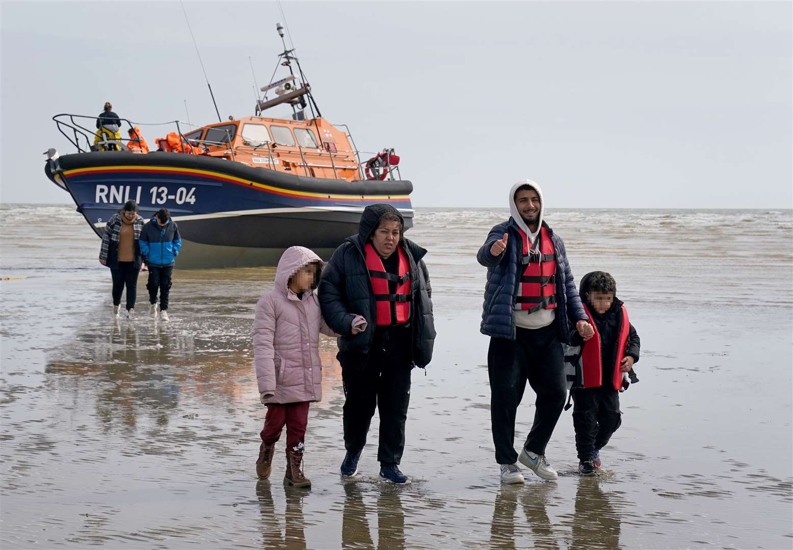 Migrants walk up the beach in Dungeness, Kent (Gareth Fuller/PA)