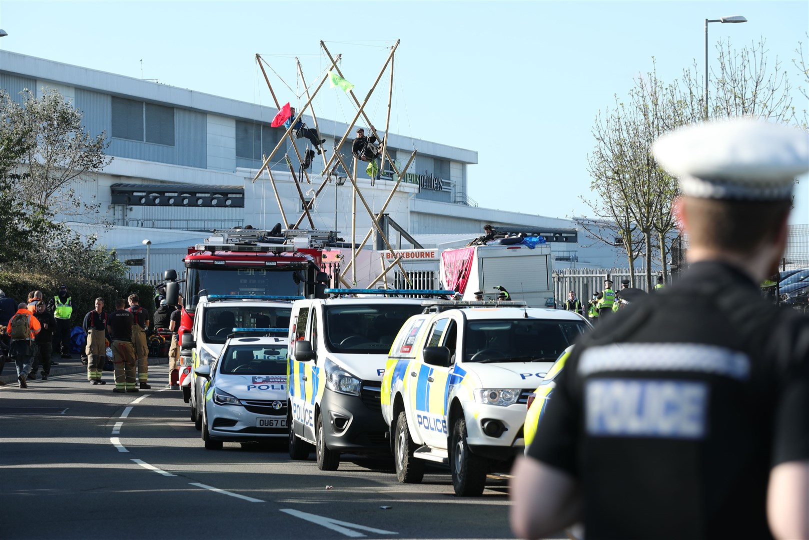 Police and fire services outside the Newsprinters printing works at Broxbourne, Hertfordshire, as protesters use bamboo lock-ons continue to block the road (PA)