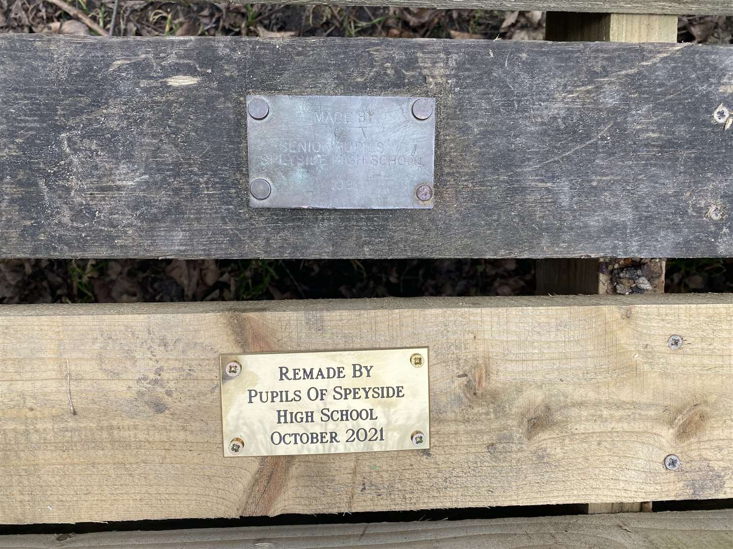 Original and new plaques commemorating Speyside High Pupils building benches.